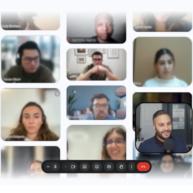 A video-call grid of twelve tiles on a white background, every tile blurred except the bottom-right one: a bearded man in a navy shirt speaking into a black desktop microphone, with a dark call toolbar of control icons floating across the bottom.